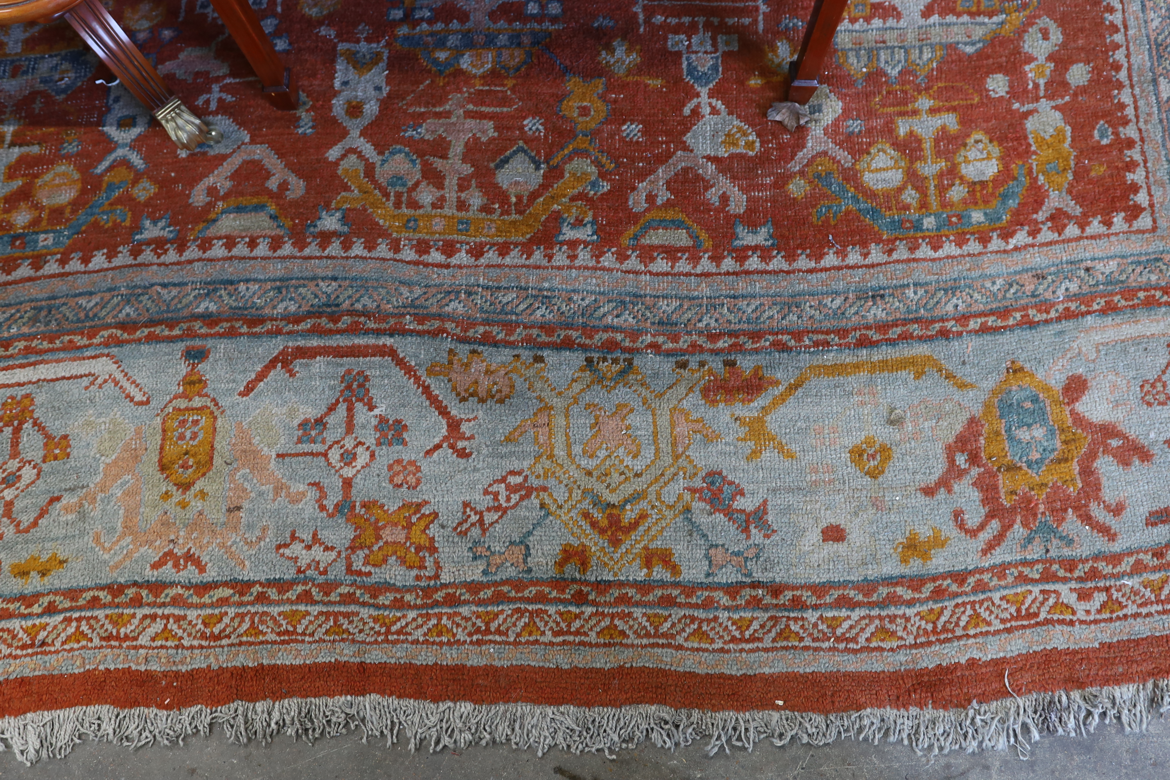 An Afghan red ground carpet, 395 x 310cm